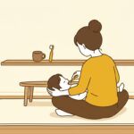 ひざの上に寝転んだ子どもの歯を、歯ブラシでみがく保護者の後ろ姿
